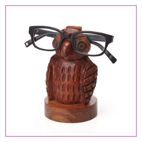 A wooded Owl with black glasses sitting on top
